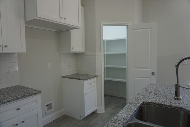 kitchen featuring sink, white cabinetry, and backsplash