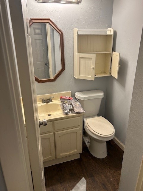 bathroom featuring toilet, vanity, and hardwood / wood-style flooring