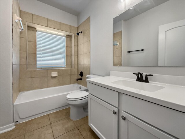 full bathroom with tile patterned flooring, toilet, vanity, and tiled shower / bath