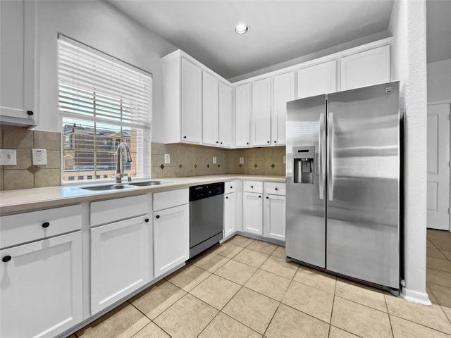 kitchen with sink, light tile patterned floors, appliances with stainless steel finishes, tasteful backsplash, and white cabinets