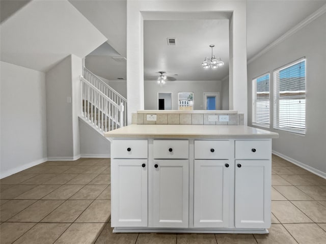 kitchen with light tile patterned floors, decorative light fixtures, a chandelier, and white cabinets