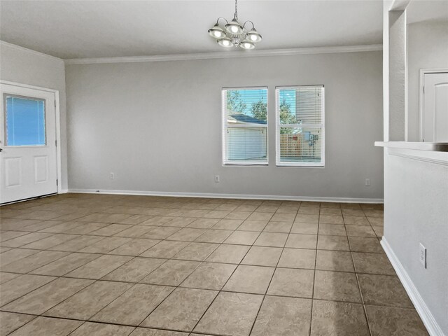 tiled spare room with ornamental molding and a chandelier