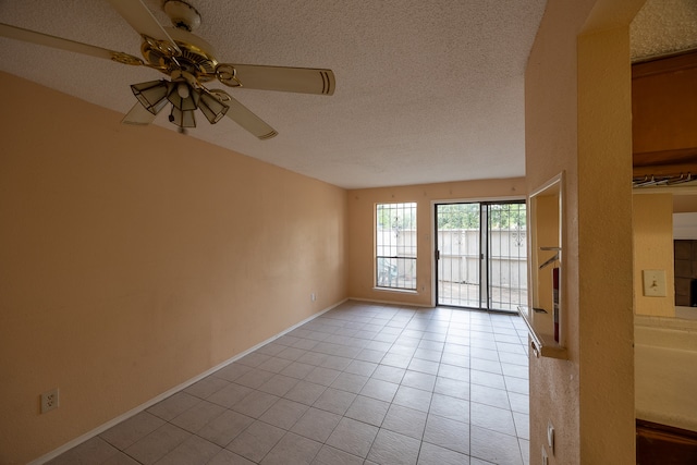 unfurnished room featuring a textured ceiling, light tile patterned floors, and ceiling fan