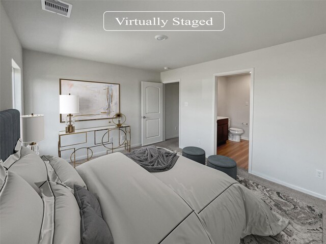 bedroom featuring hardwood / wood-style flooring and connected bathroom