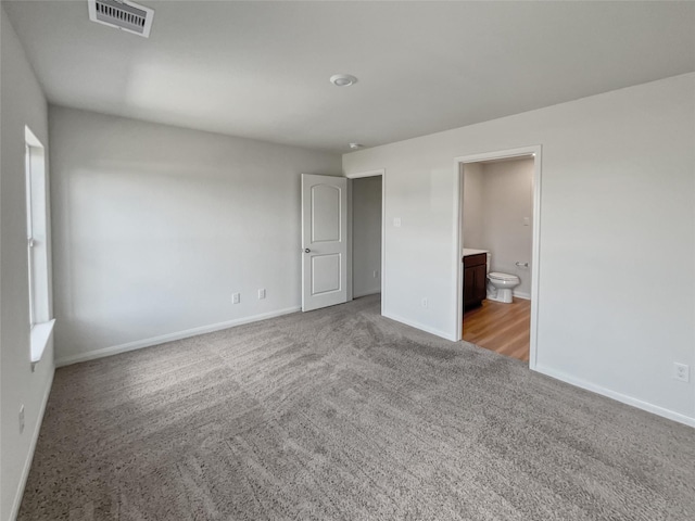 unfurnished bedroom with light carpet and ensuite bathroom