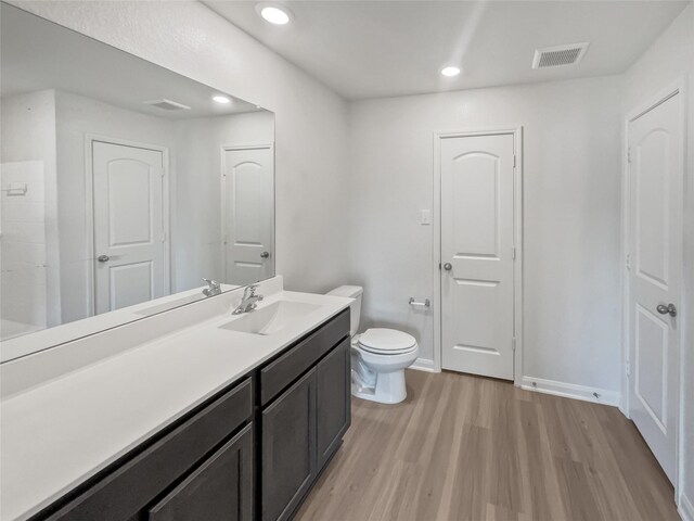 bathroom featuring hardwood / wood-style flooring, toilet, and vanity