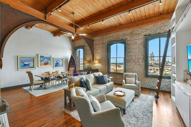 living room featuring track lighting, wood-type flooring, brick wall, wood ceiling, and beamed ceiling