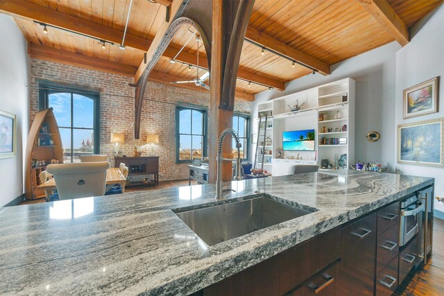 kitchen featuring sink, stone countertops, dark hardwood / wood-style flooring, wooden ceiling, and brick wall