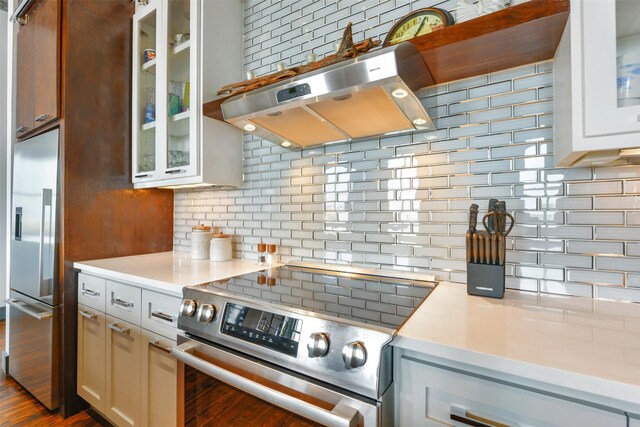 kitchen featuring white cabinets, tasteful backsplash, stainless steel appliances, and extractor fan