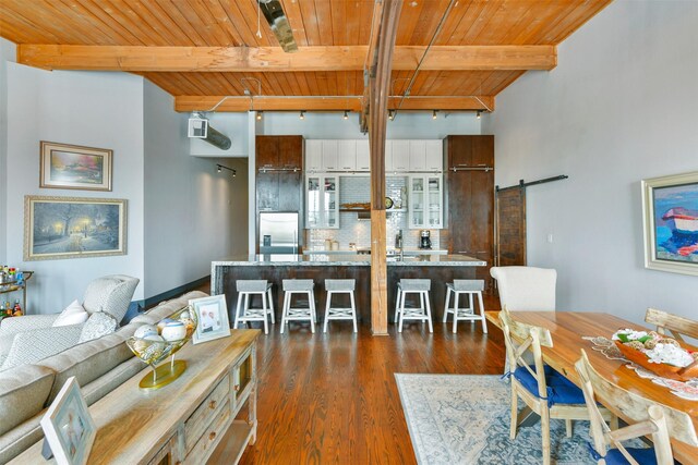 kitchen with backsplash, beamed ceiling, built in refrigerator, wooden ceiling, and a barn door