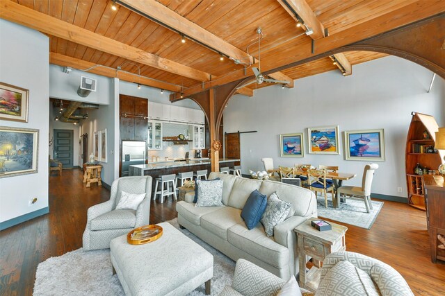 living room with rail lighting, wooden ceiling, dark hardwood / wood-style floors, and beam ceiling