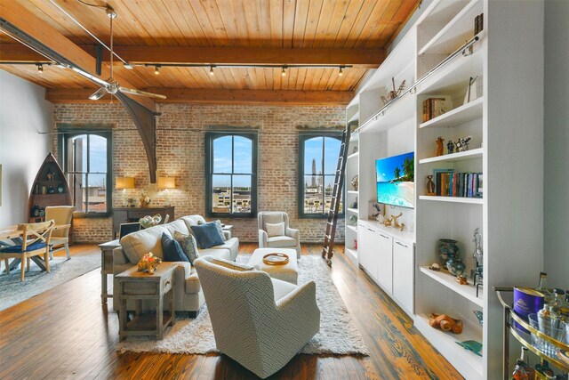 living area featuring plenty of natural light, brick wall, wood-type flooring, and wooden ceiling