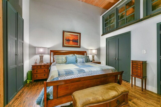 bedroom featuring a high ceiling, a closet, and dark hardwood / wood-style floors