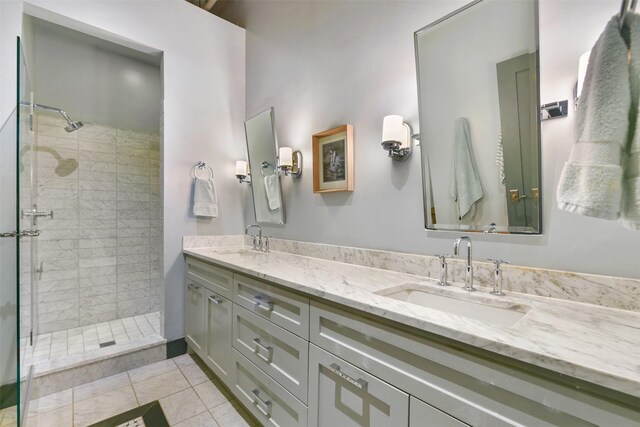 bathroom with tile patterned floors, vanity, and tiled shower