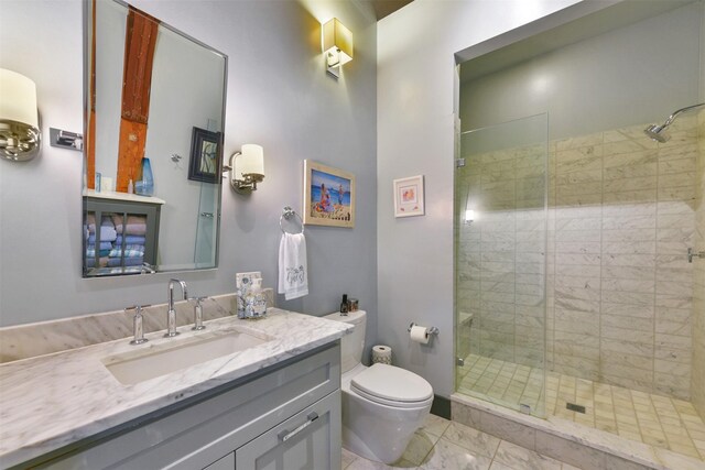 bathroom with toilet, vanity, and a shower with shower door