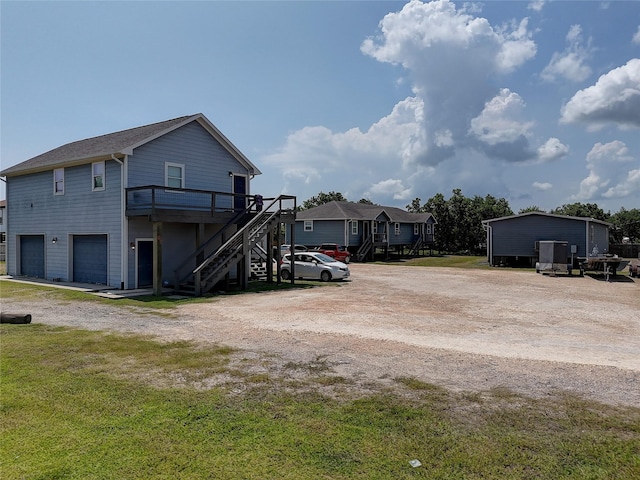 exterior space with a garage, driveway, a deck, and stairway