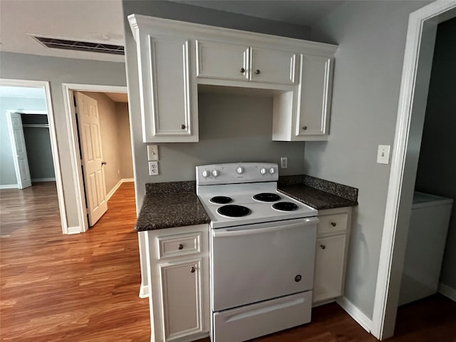 kitchen with white cabinetry, wood finished floors, visible vents, and white range with electric cooktop