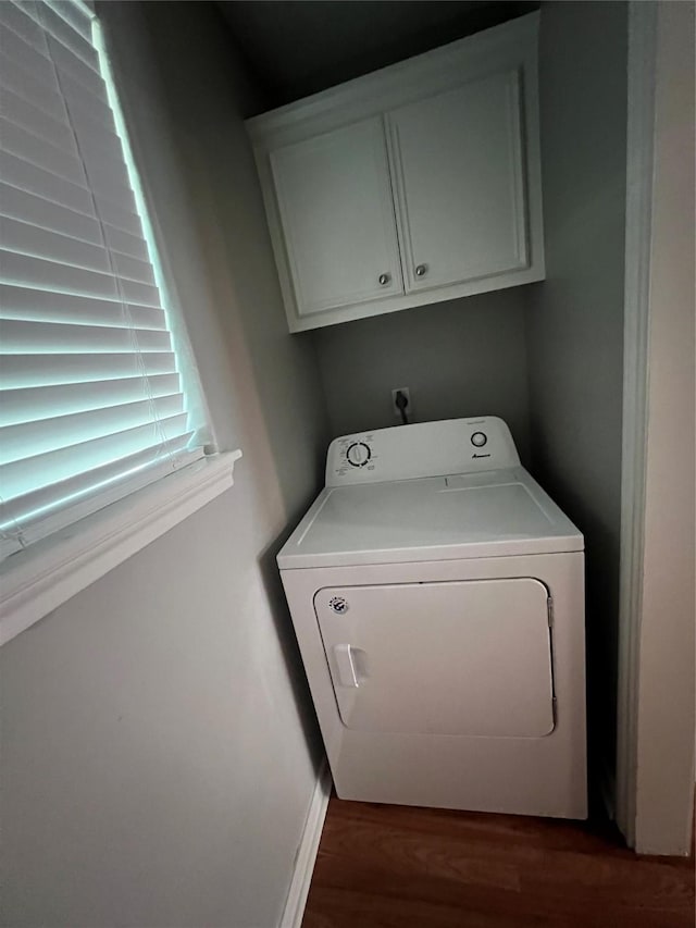 laundry area with washer / clothes dryer, cabinet space, baseboards, and wood finished floors