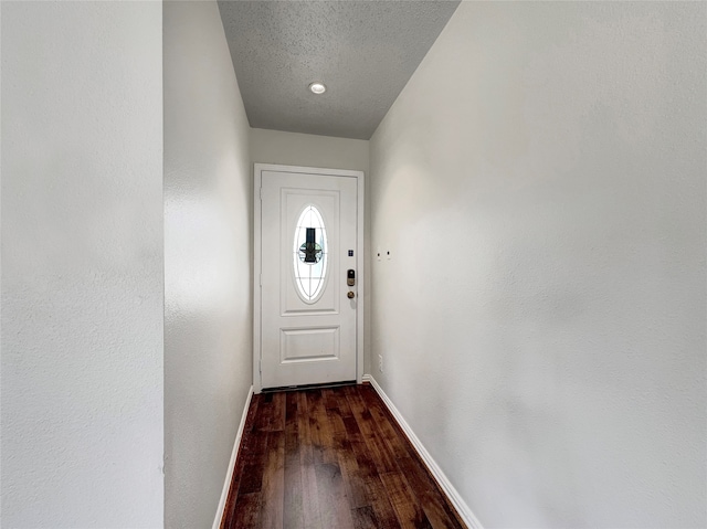 doorway to outside with a textured ceiling and wood-type flooring