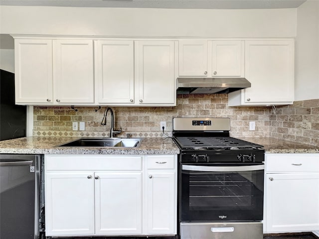 kitchen with white cabinets, stainless steel appliances, light stone countertops, decorative backsplash, and sink