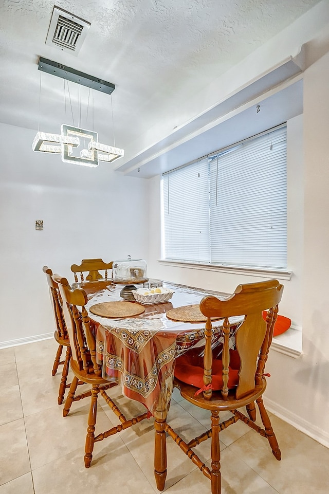 dining room featuring a textured ceiling and light tile patterned floors