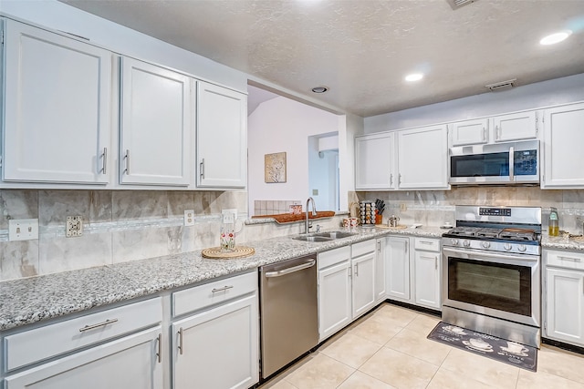 kitchen featuring white cabinetry, light tile patterned flooring, tasteful backsplash, sink, and appliances with stainless steel finishes