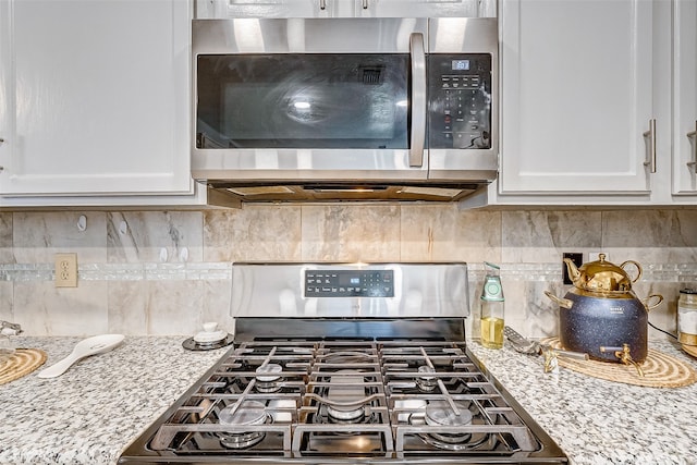 kitchen featuring white cabinetry, range, and backsplash