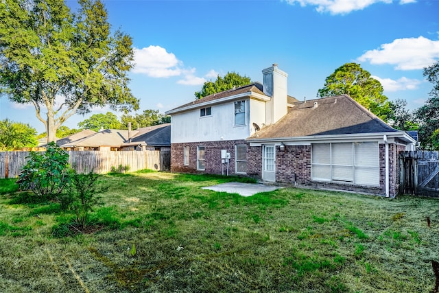 rear view of house with a yard