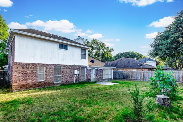 rear view of house featuring a patio area and a yard