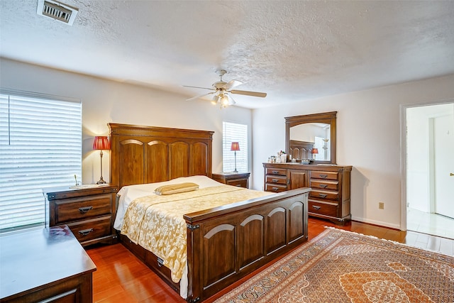 bedroom featuring ceiling fan, a textured ceiling, and hardwood / wood-style flooring