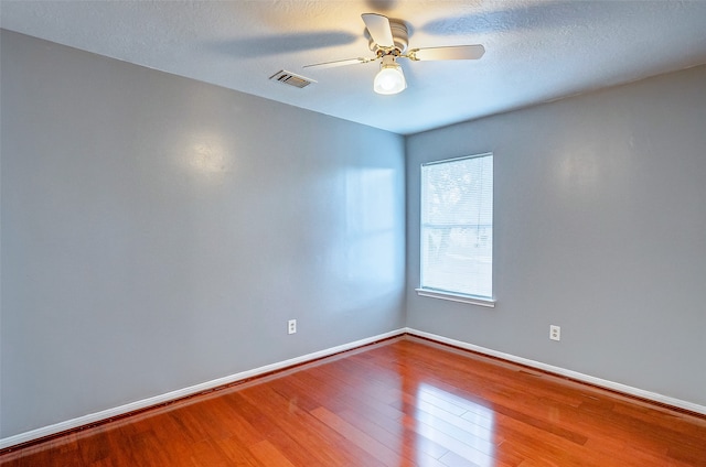 spare room with ceiling fan, a textured ceiling, and hardwood / wood-style flooring