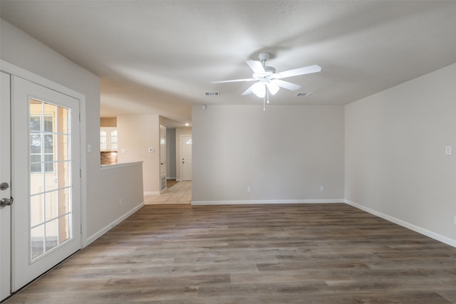 unfurnished room featuring a healthy amount of sunlight, french doors, ceiling fan, and hardwood / wood-style floors