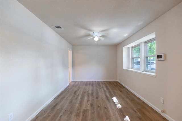 spare room with a textured ceiling, ceiling fan, and hardwood / wood-style floors