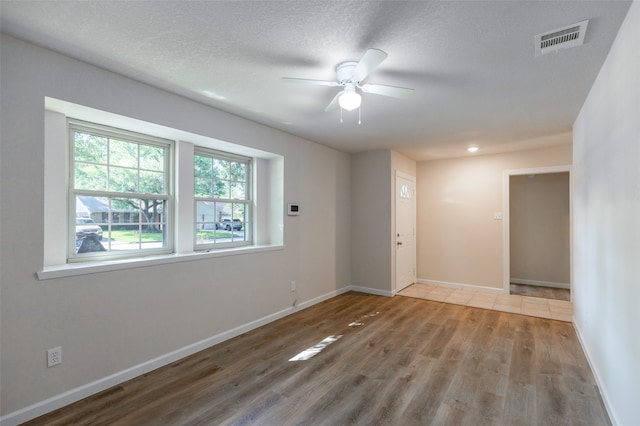 unfurnished room with a textured ceiling, ceiling fan, and hardwood / wood-style floors