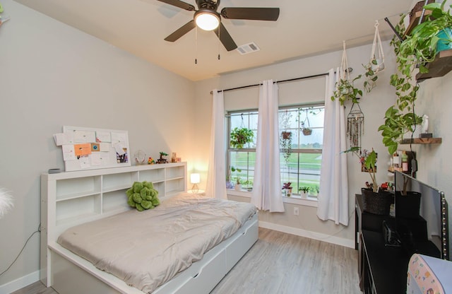 bedroom featuring a ceiling fan, baseboards, visible vents, and light wood finished floors