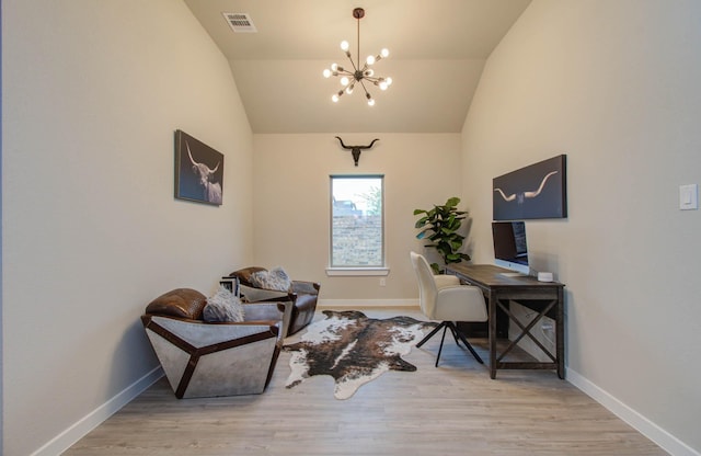 office space featuring lofted ceiling, an inviting chandelier, and wood finished floors