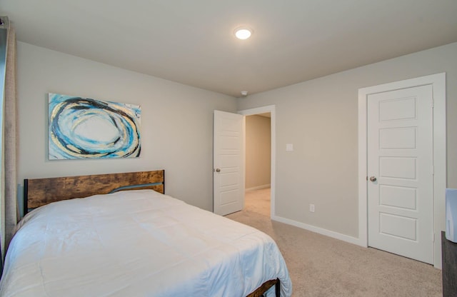 bedroom with baseboards and light colored carpet