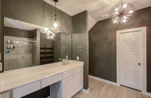 bathroom featuring a stall shower, baseboards, wood finished floors, vanity, and a notable chandelier