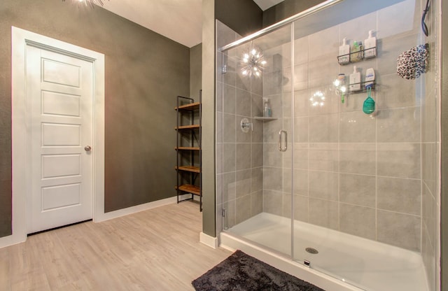 full bathroom with a shower stall, baseboards, and wood finished floors