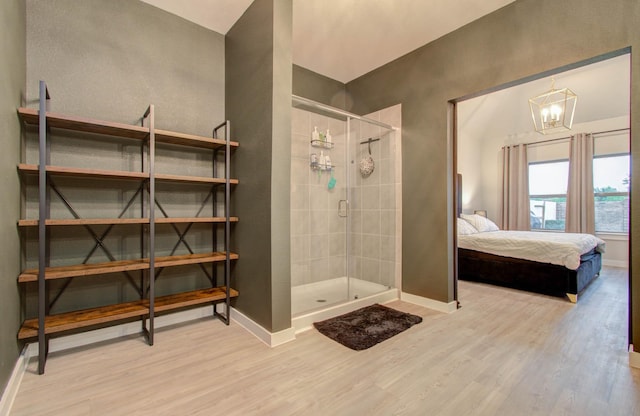 5727 Daylight Cv, Fulshear, TX 77441 - ensuite bathroom with baseboards, wood finished floors, a stall shower, and a chandelier
