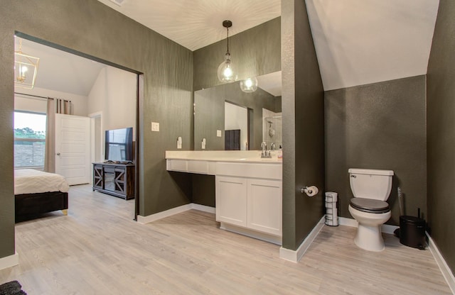 ensuite bathroom with vanity, wood finished floors, toilet, and baseboards