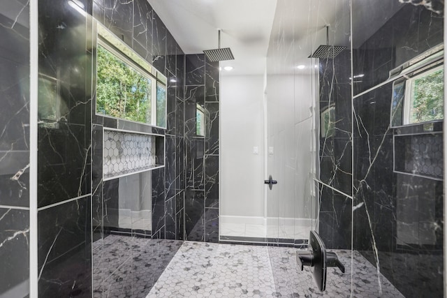 bathroom featuring a tile shower and a wealth of natural light