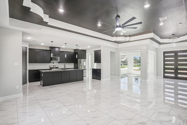 living room featuring a textured ceiling, a raised ceiling, sink, and ceiling fan