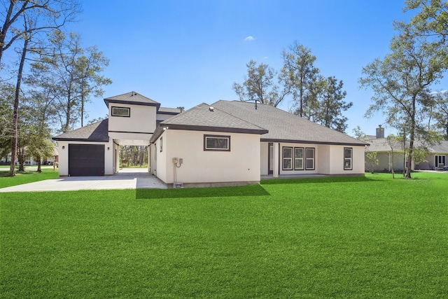 rear view of property with a garage and a yard