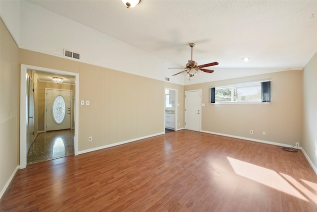 interior space with a textured ceiling, lofted ceiling, tile patterned flooring, and ceiling fan