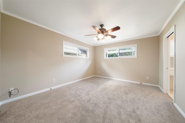 empty room with ornamental molding, light colored carpet, and ceiling fan