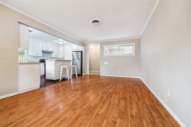 unfurnished living room featuring light hardwood / wood-style floors and crown molding