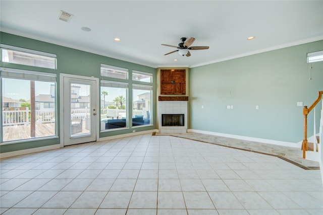 unfurnished living room with a fireplace, ceiling fan, crown molding, and light tile patterned floors