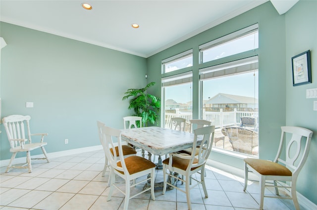 dining area featuring light tile patterned floors, a wealth of natural light, and crown molding