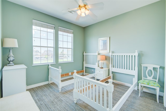 bedroom with ceiling fan and a crib